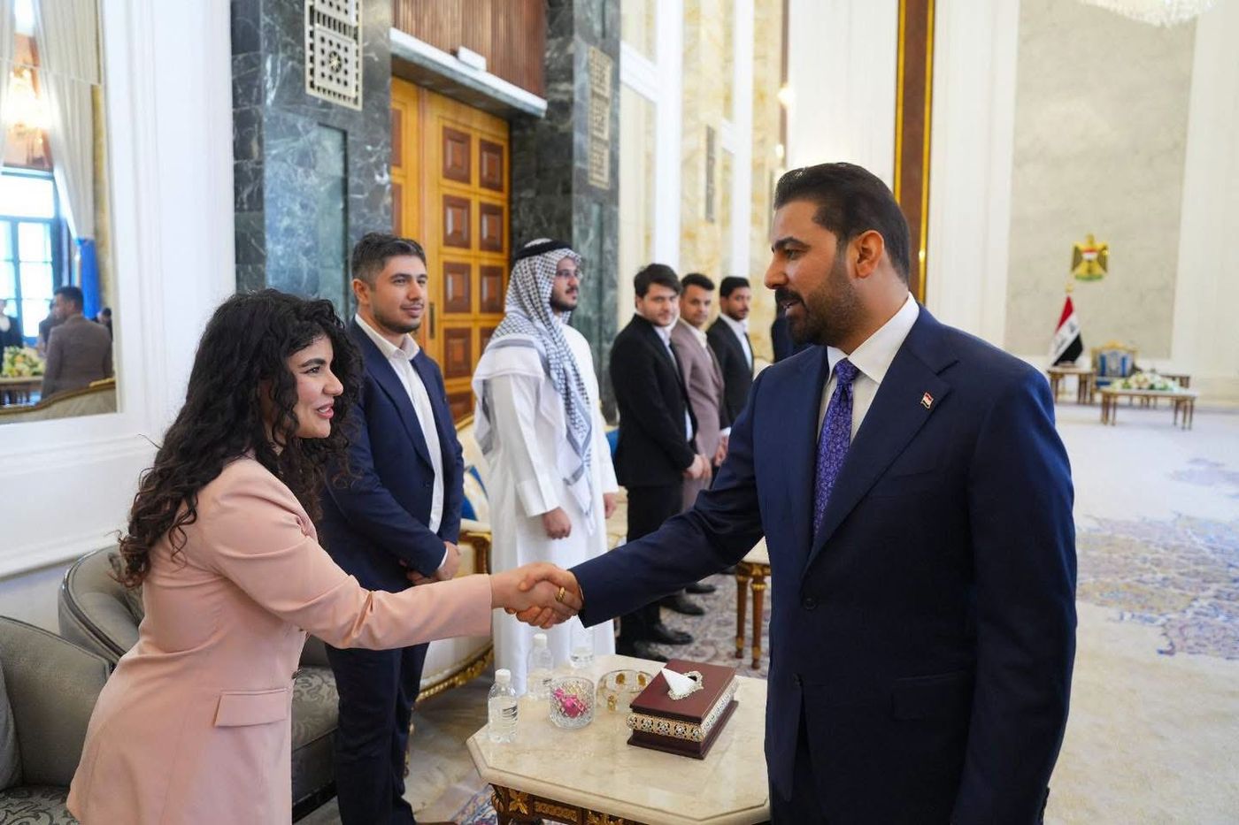 Young woman shaking hands with officials