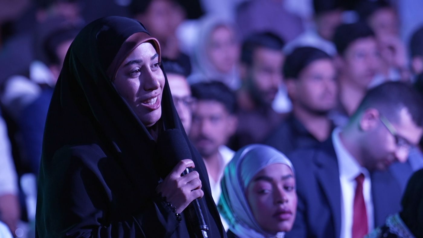 Young woman asking a question at an event