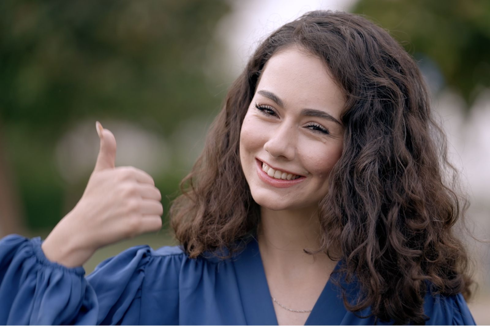 Smiling young Iraqi woman giving a thumbs up